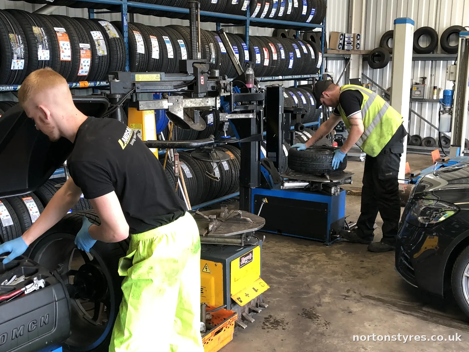 Fitters balancing car wheels in the Nortons Tyres car bay, detail Fitters balancing car wheels in the Nortons Tyres car bay, detail