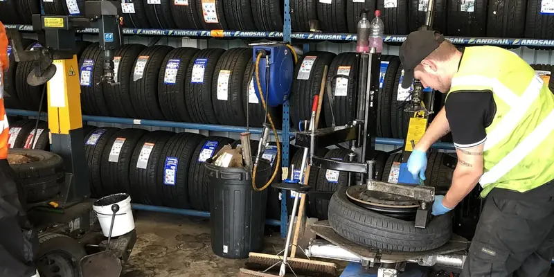 Car tyre being removed from the wheel on the tyre changer, detail Car tyre being removed from the wheel on the tyre changer, detail