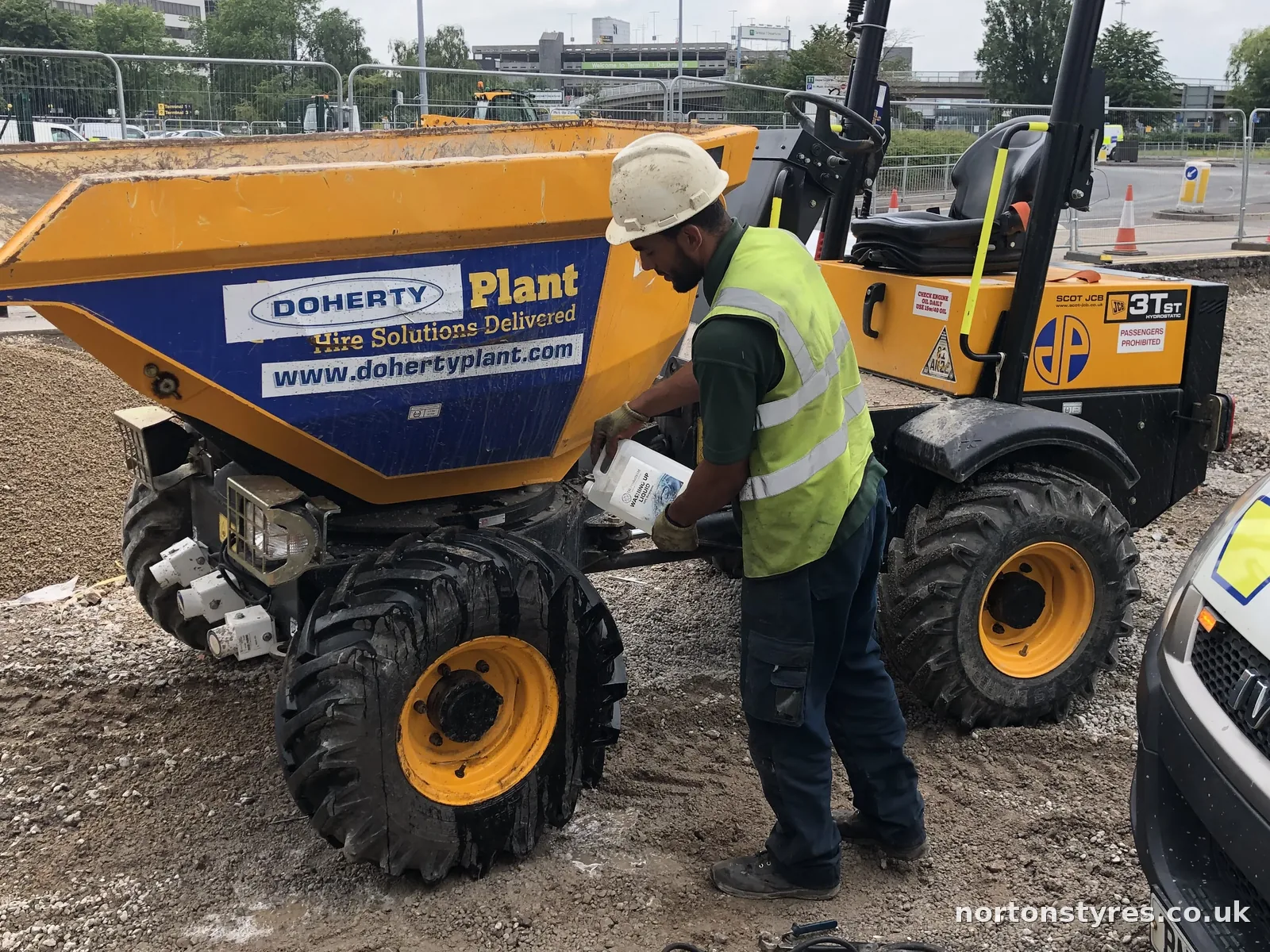 Fitter checking the tyres on a site dumper, close view Fitter checking the tyres on a site dumper, close view