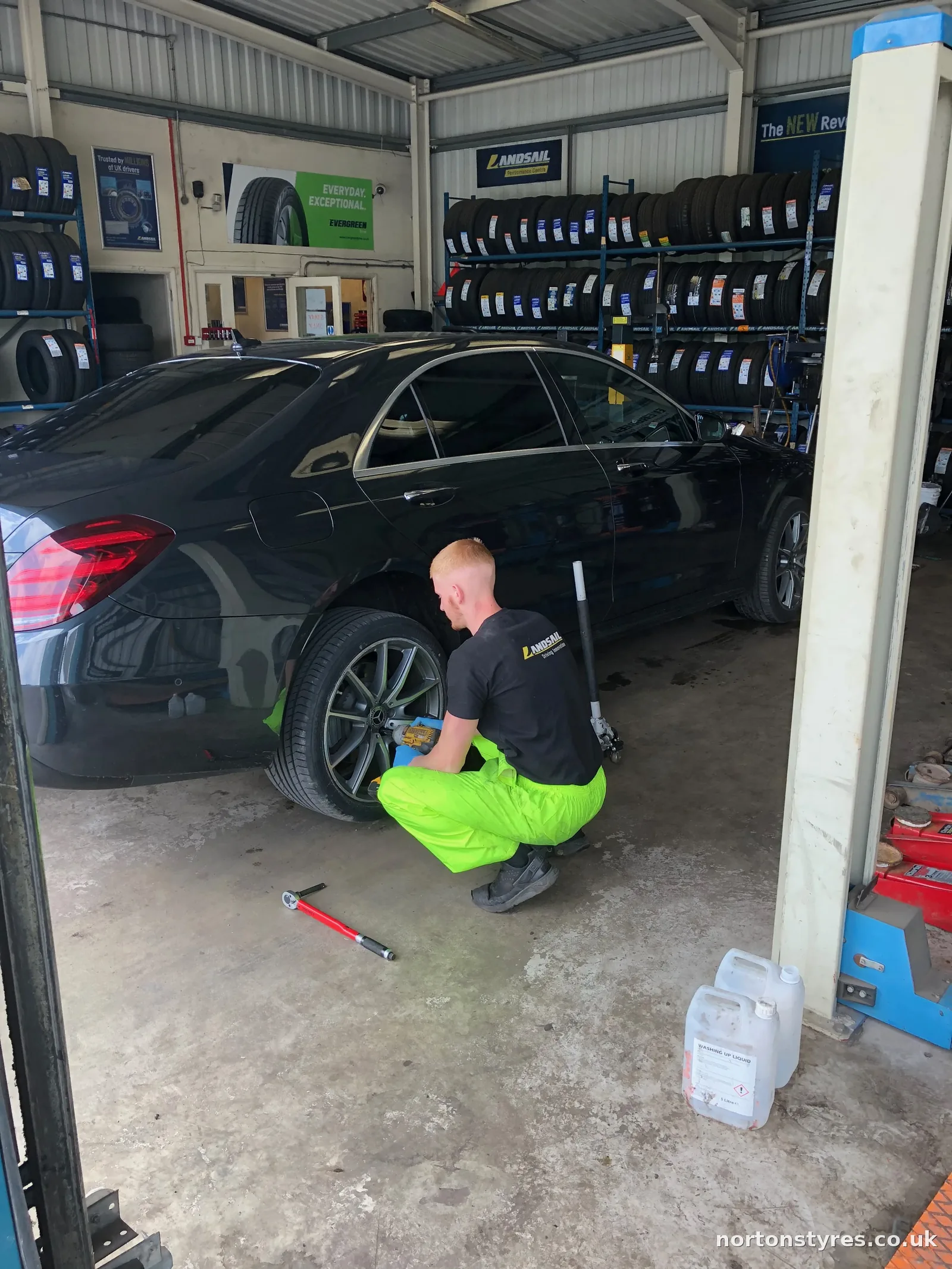 Fitter tightening a car wheel in the Nortons Tyres bay Fitter tightening a car wheel in the Nortons Tyres bay