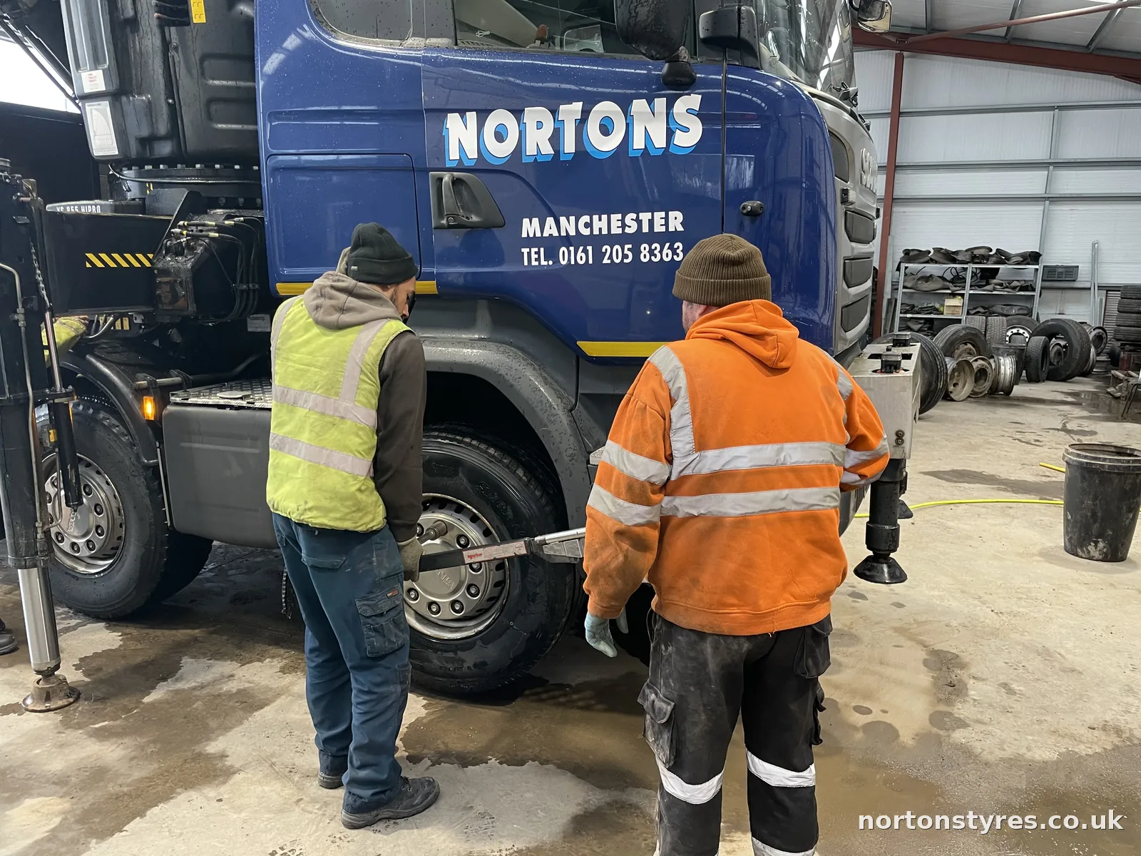 Fitters changing a wheel on a Nortons lorry in the commercial bay Fitters changing a wheel on a Nortons lorry in the commercial bay