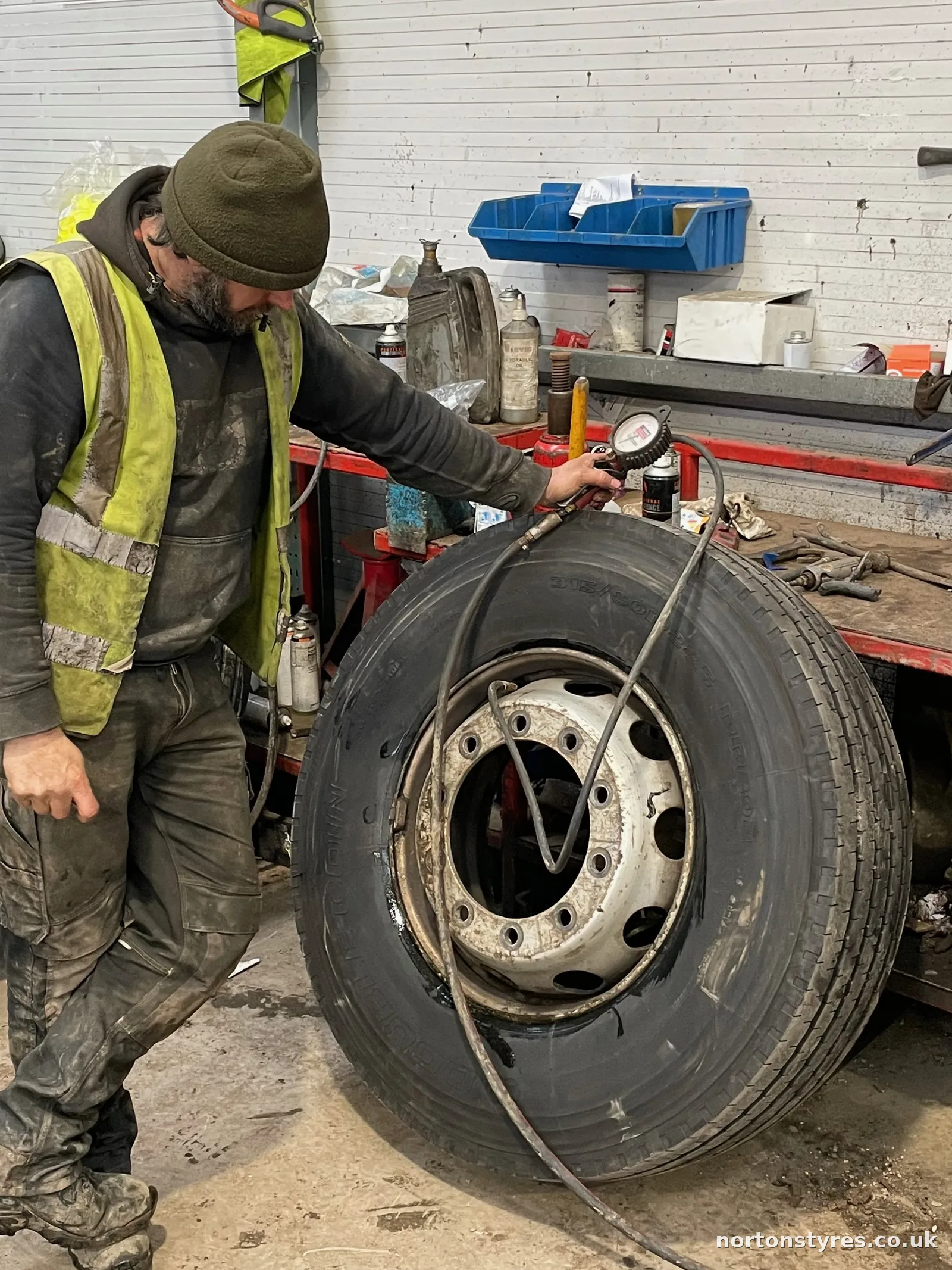 Fitter removing a truck wheel in the commercial tyre bay, close view