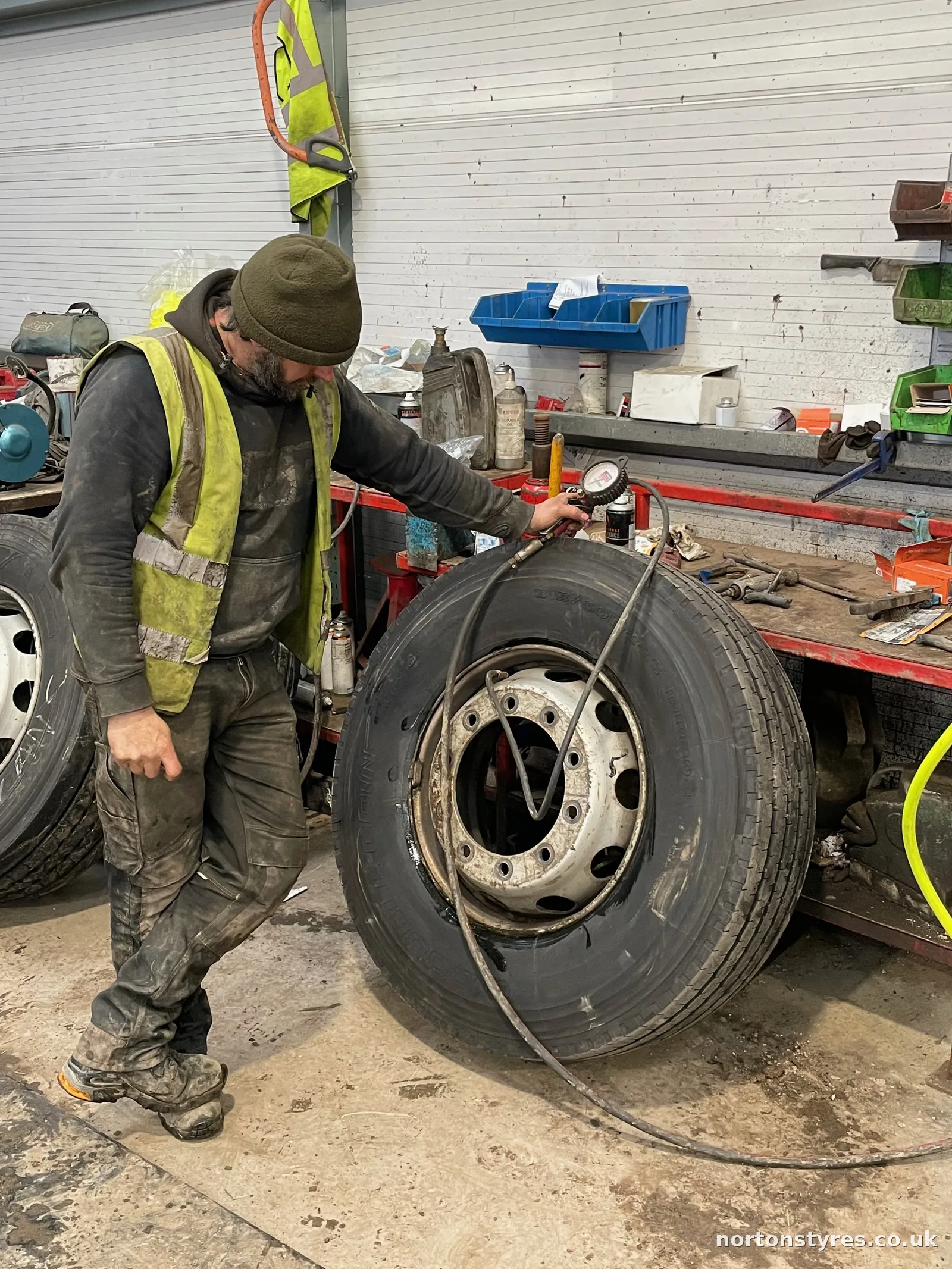 Fitter removing a truck wheel in the commercial tyre bay Fitter removing a truck wheel in the commercial tyre bay