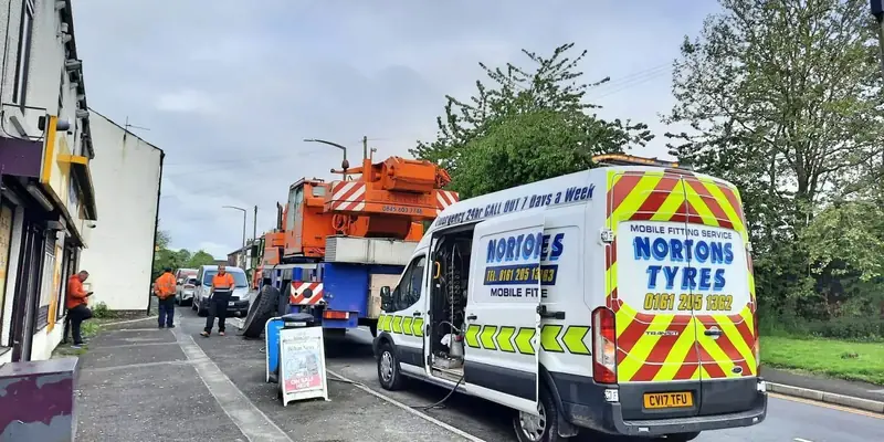 Nortons van attending a mobile crane in a residential street Nortons van attending a mobile crane in a residential street
