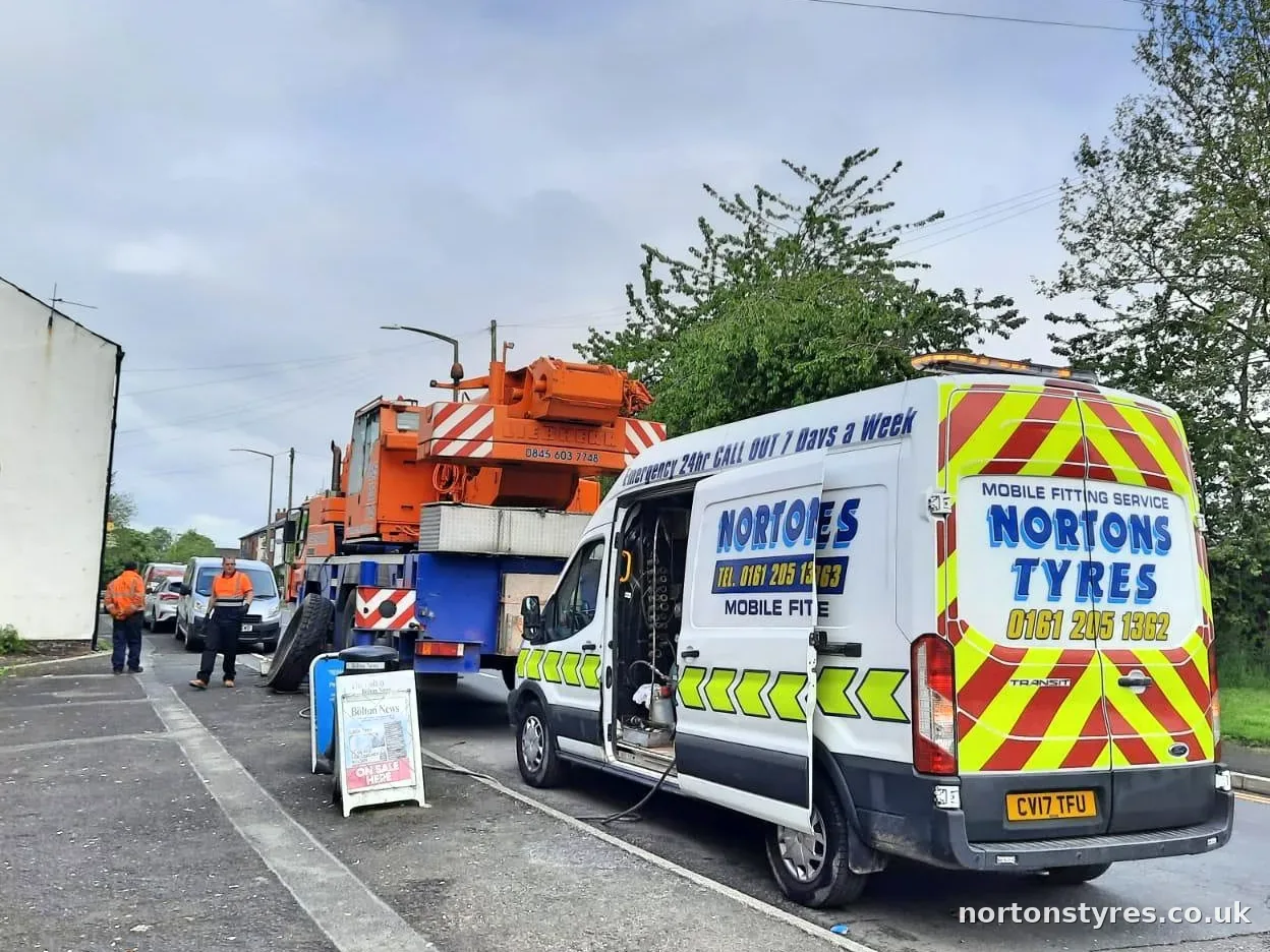 Nortons Tyres van attending a mobile crane in a residential street, close view Nortons Tyres van attending a mobile crane in a residential street, close view