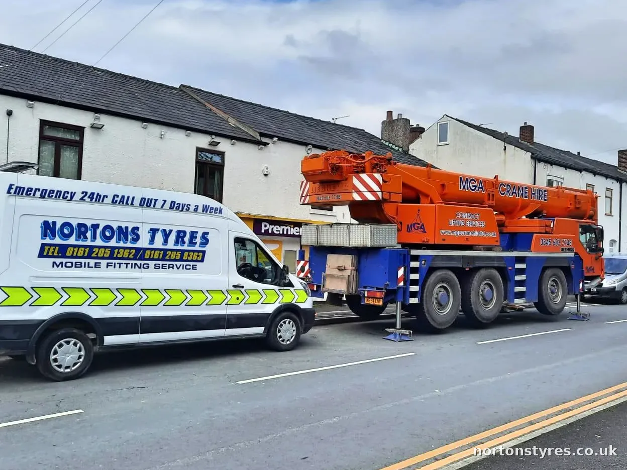 Nortons Tyres mobile fitting van parked beside a mobile crane, close view Nortons Tyres mobile fitting van parked beside a mobile crane, close view