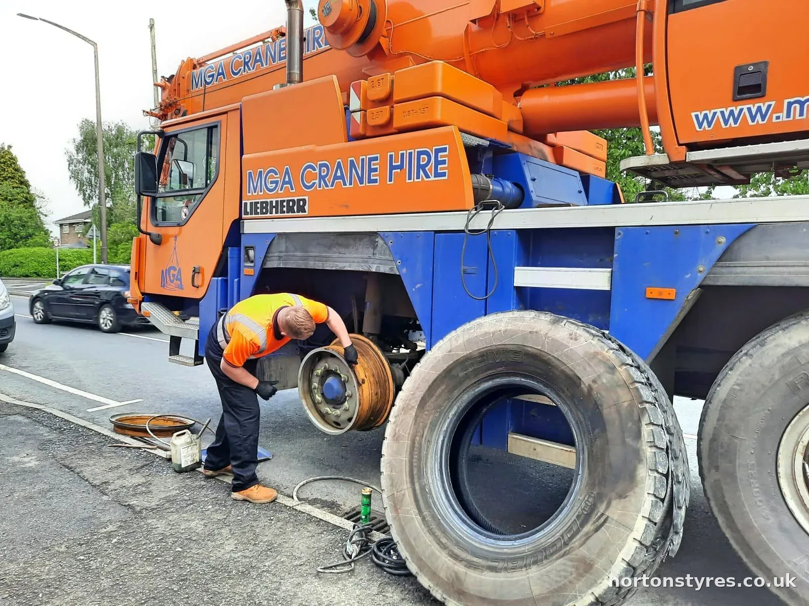 Fitter changing a mobile crane tyre at the kerbside Fitter changing a mobile crane tyre at the kerbside