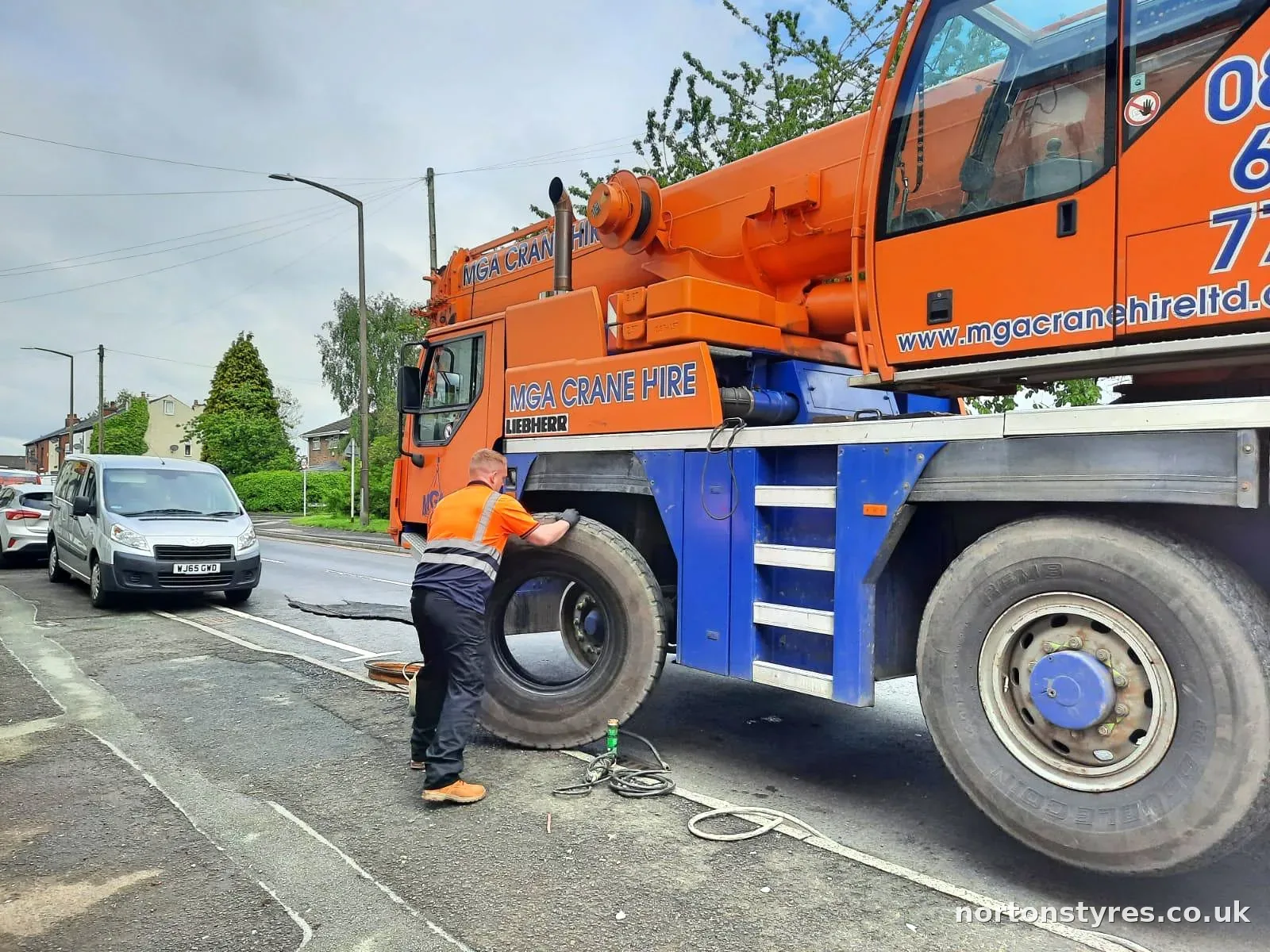 Fitter lifting a crane tyre into place Fitter lifting a crane tyre into place