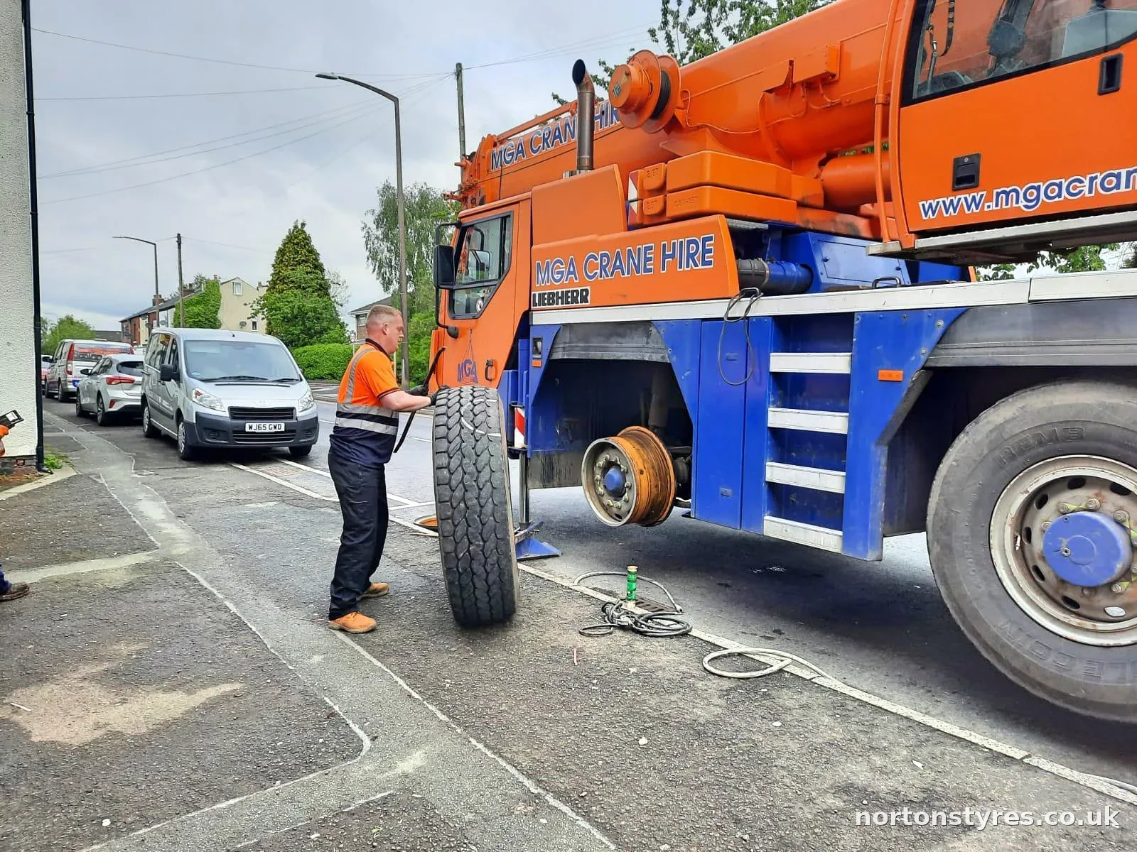 Fitter standing a large crane tyre upright beside the crane Fitter standing a large crane tyre upright beside the crane