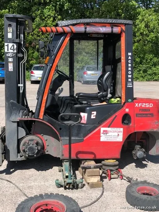 Forklift with a wheel off and its tyres being changed, detail Forklift with a wheel off and its tyres being changed, detail