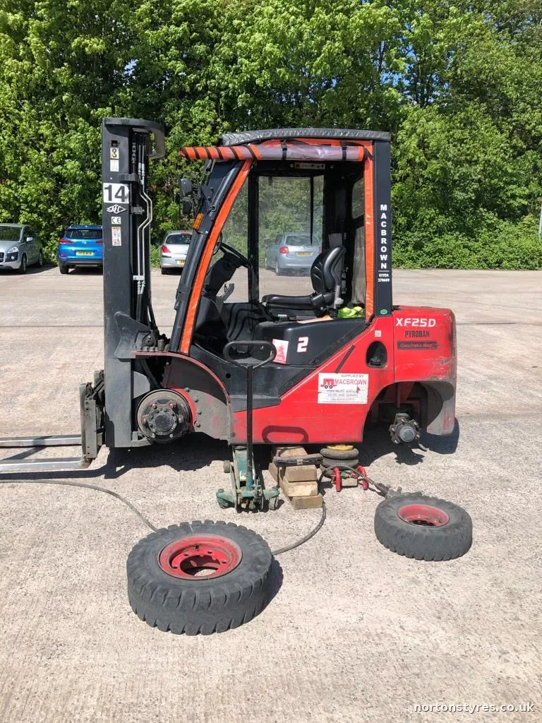 Forklift with a wheel off and its tyres being changed Forklift with a wheel off and its tyres being changed