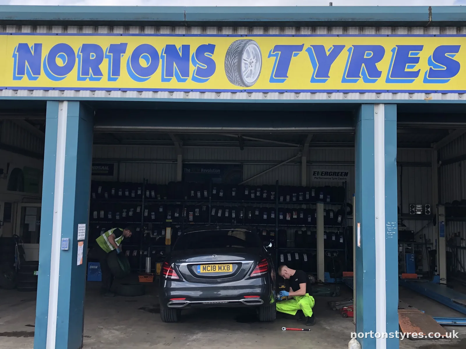 Car in the Nortons Tyres bay under the yellow sign, close view Car in the Nortons Tyres bay under the yellow sign, close view