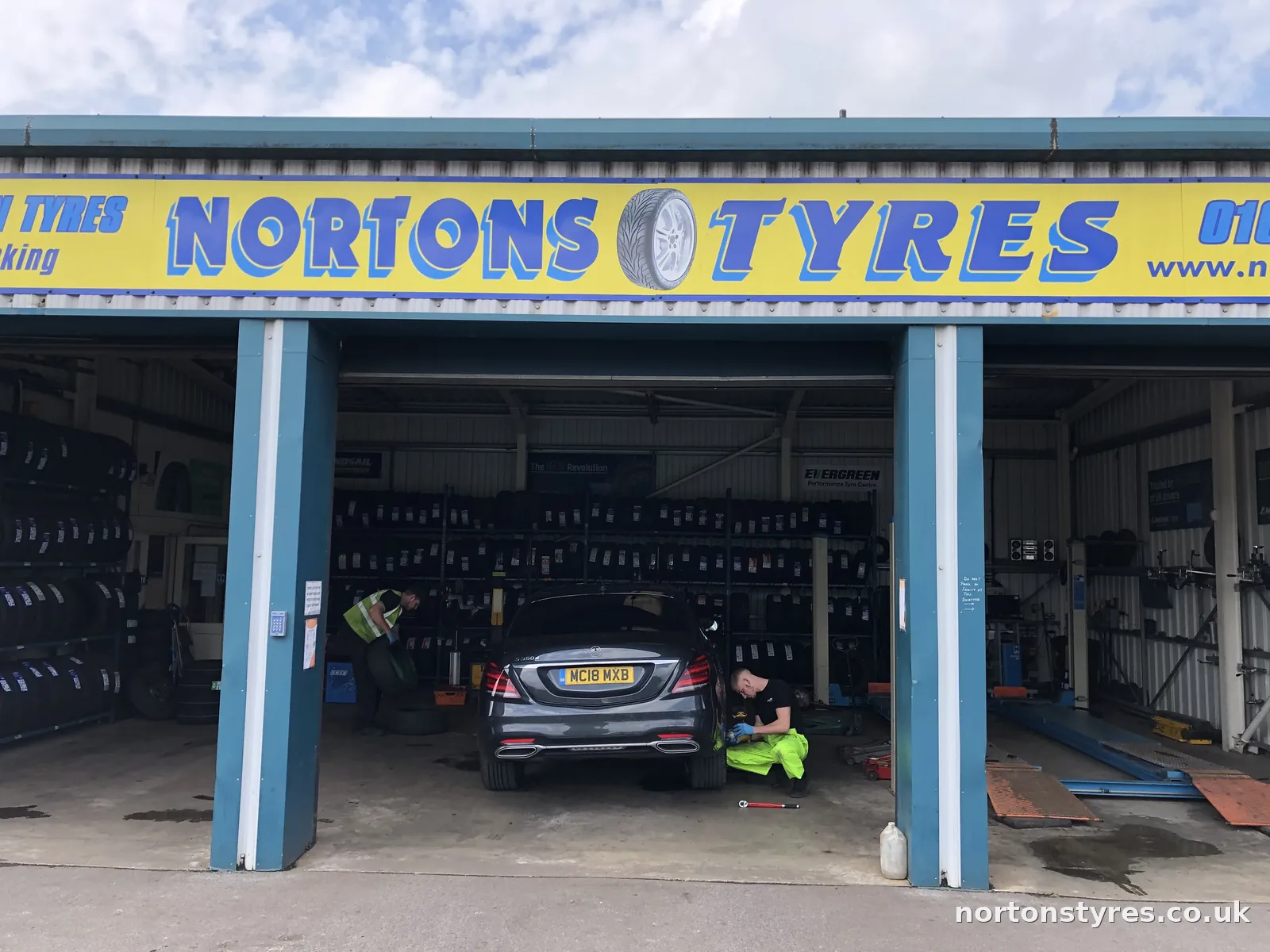 Car in the Nortons Tyres bay under the yellow sign Car in the Nortons Tyres bay under the yellow sign