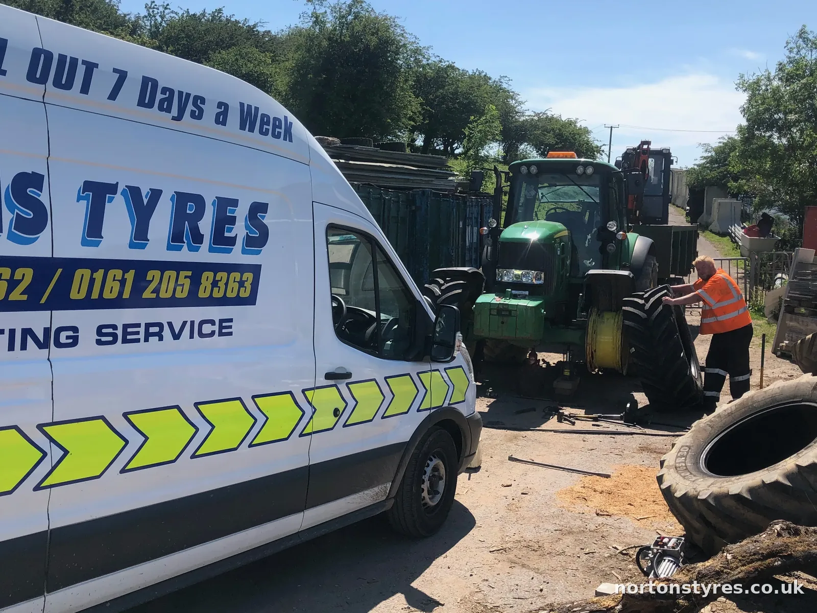 Nortons Tyres van beside a tractor on a farm call-out, close view Nortons Tyres van beside a tractor on a farm call-out, close view