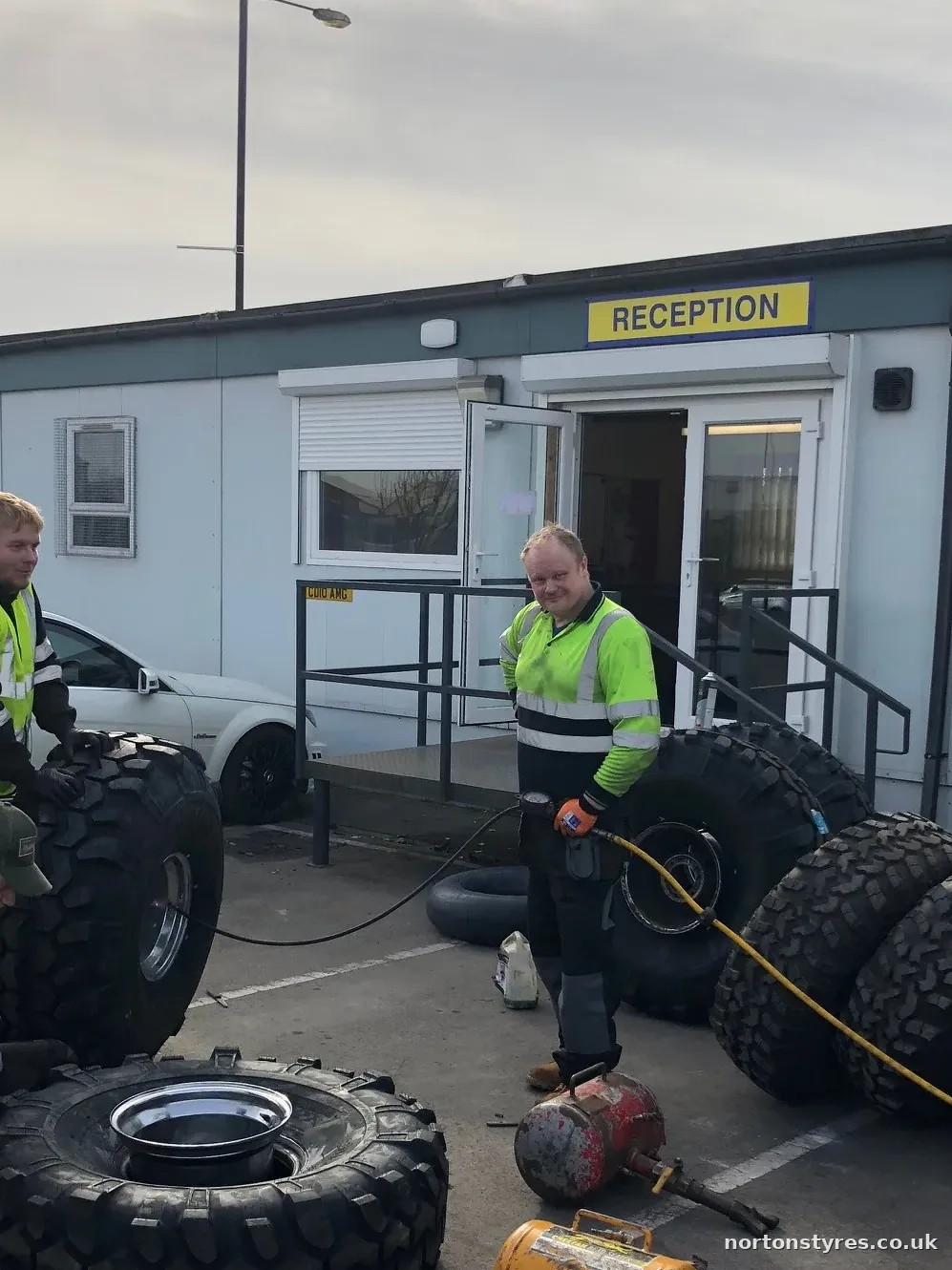 Fitters with tyres outside a site office on a call-out, detail Fitters with tyres outside a site office on a call-out, detail