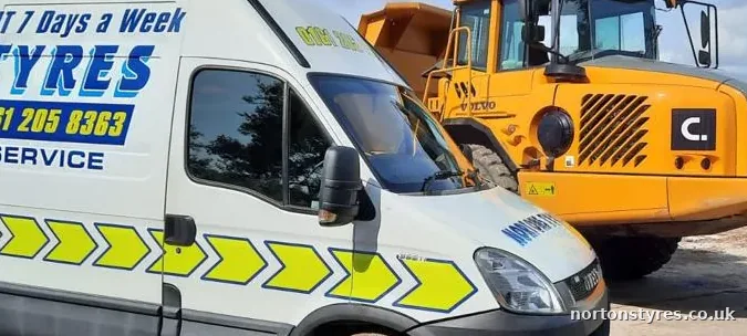 Nortons Tyres van next to an articulated dumper on site, detail Nortons Tyres van next to an articulated dumper on site, detail