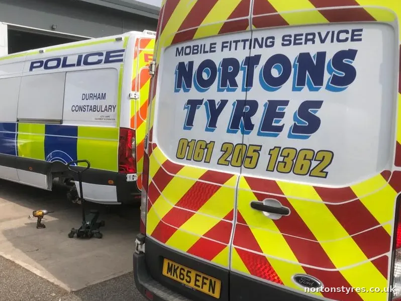 Nortons Tyres van alongside a police van, close view Nortons Tyres van alongside a police van, close view