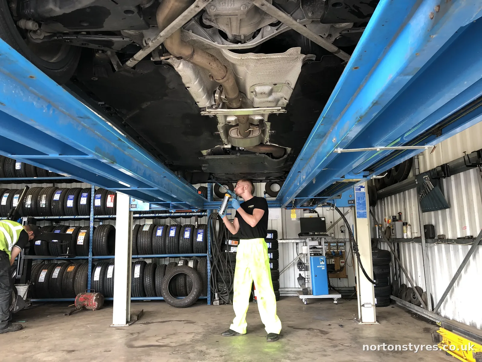 Fitter under a car on the alignment ramp Fitter under a car on the alignment ramp