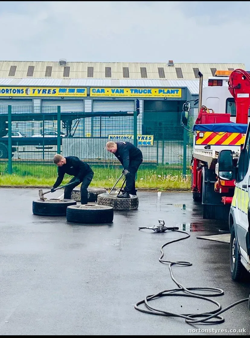 Two fitters changing truck tyres outside the bay Two fitters changing truck tyres outside the bay
