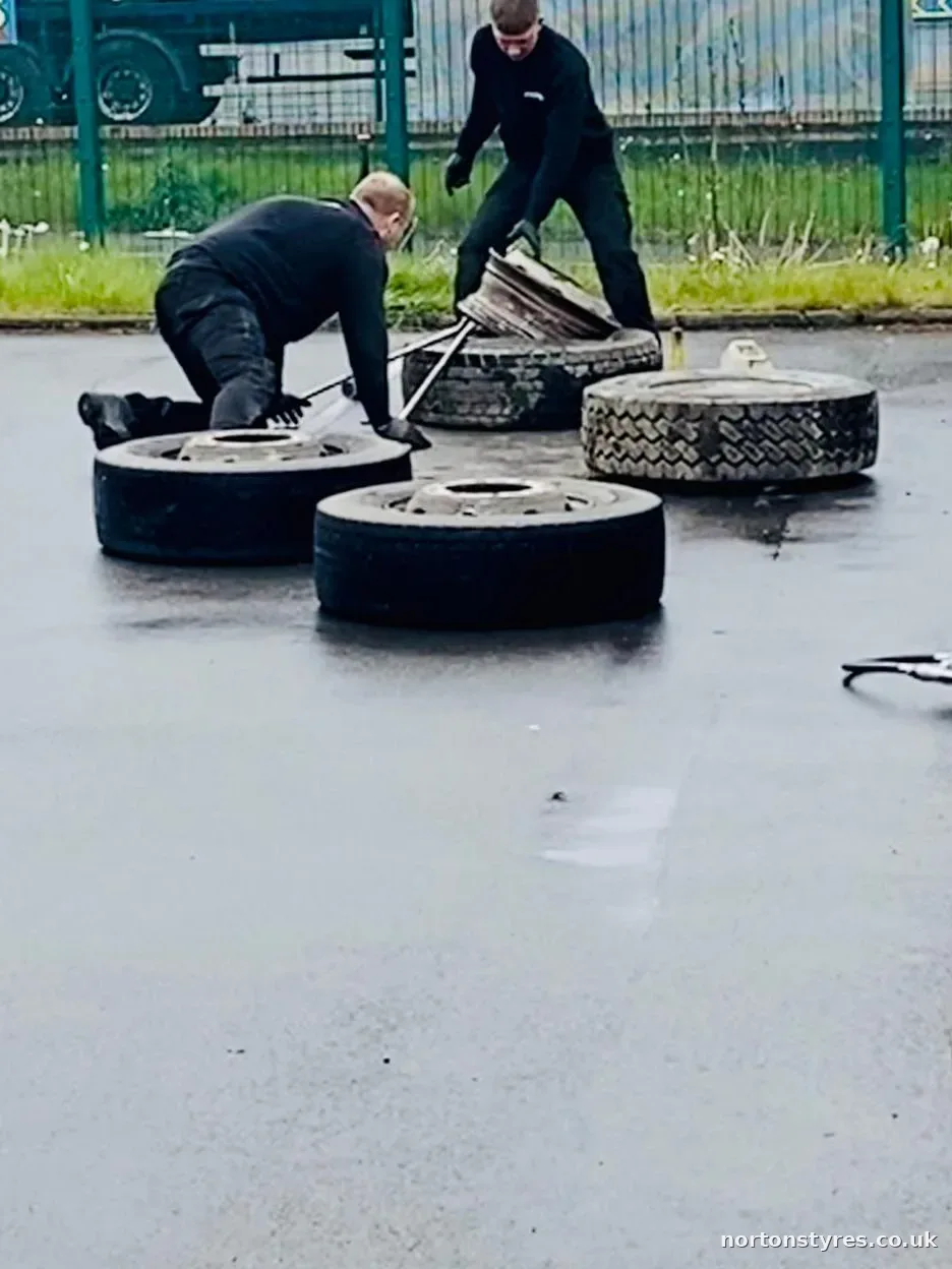 Fitters with truck wheels laid out in the yard, close view
