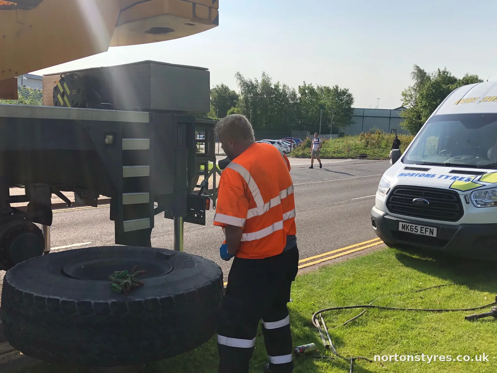 Fitter changing a lorry tyre with the Nortons van behind, close view Fitter changing a lorry tyre with the Nortons van behind, close view