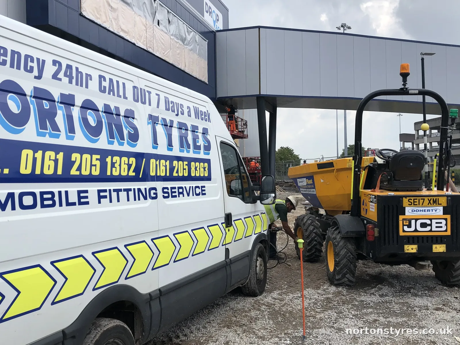 Nortons Tyres van beside a JCB dumper on a building site, close view Nortons Tyres van beside a JCB dumper on a building site, close view