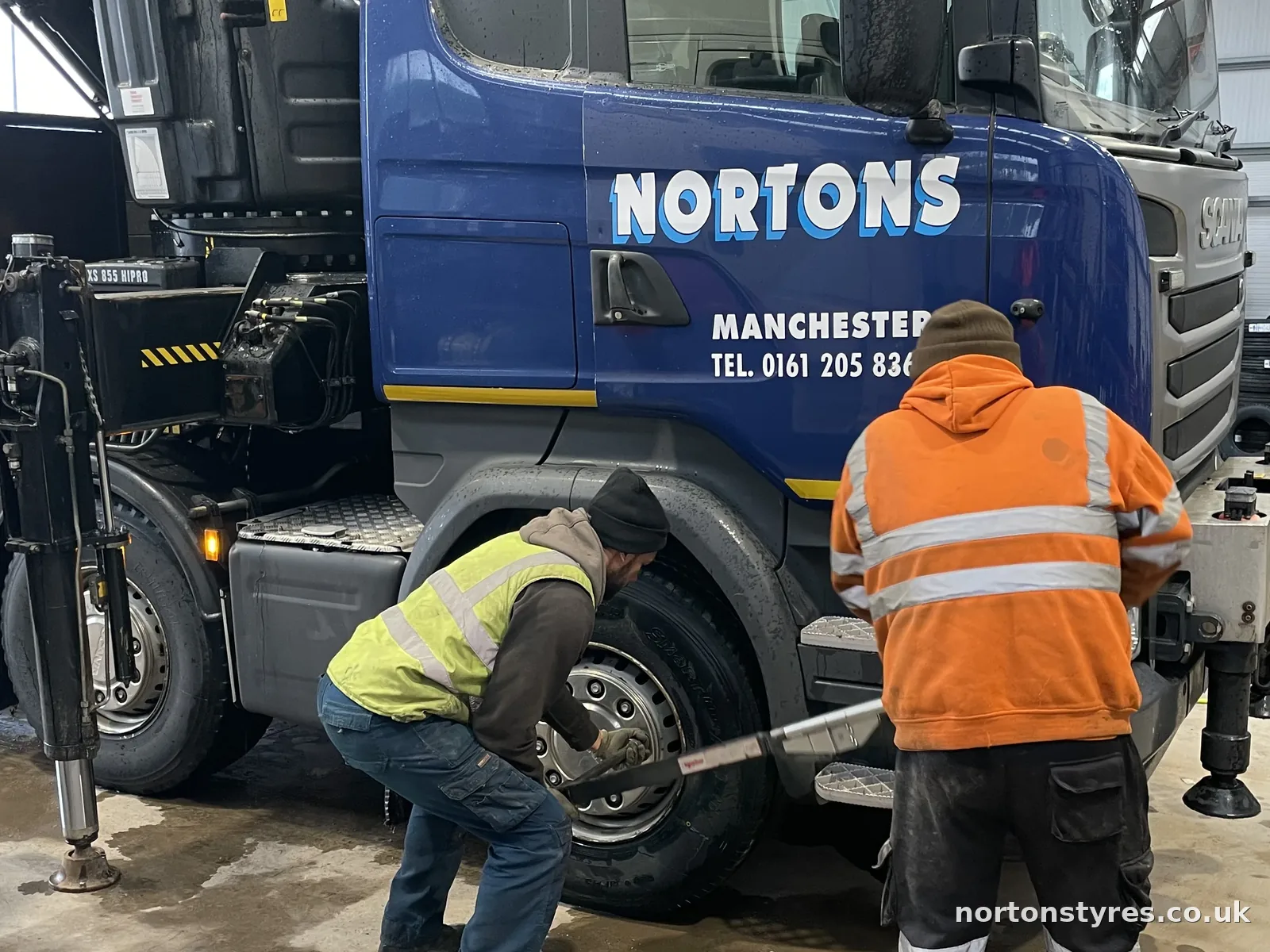 Fitters working on a Nortons lorry wheel in the workshop, detail Fitters working on a Nortons lorry wheel in the workshop, detail