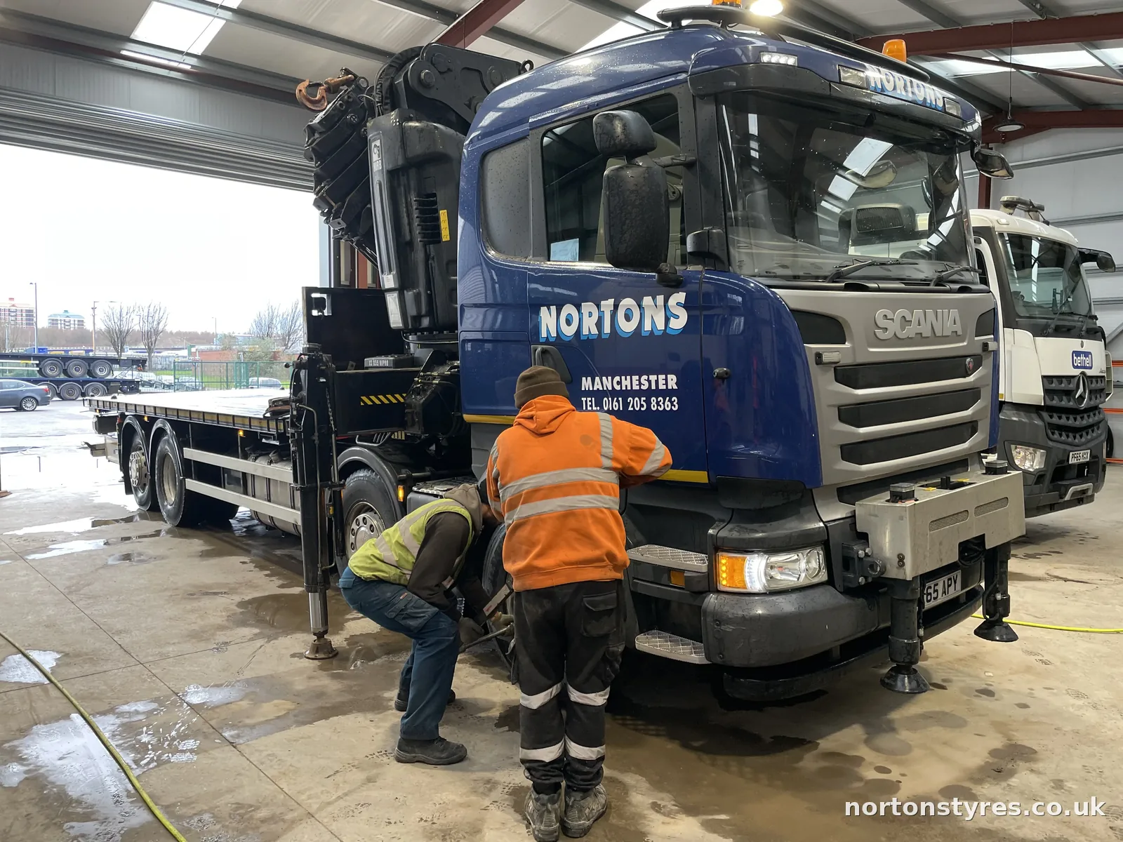 Fitters changing a Nortons lorry tyre in the workshop Fitters changing a Nortons lorry tyre in the workshop